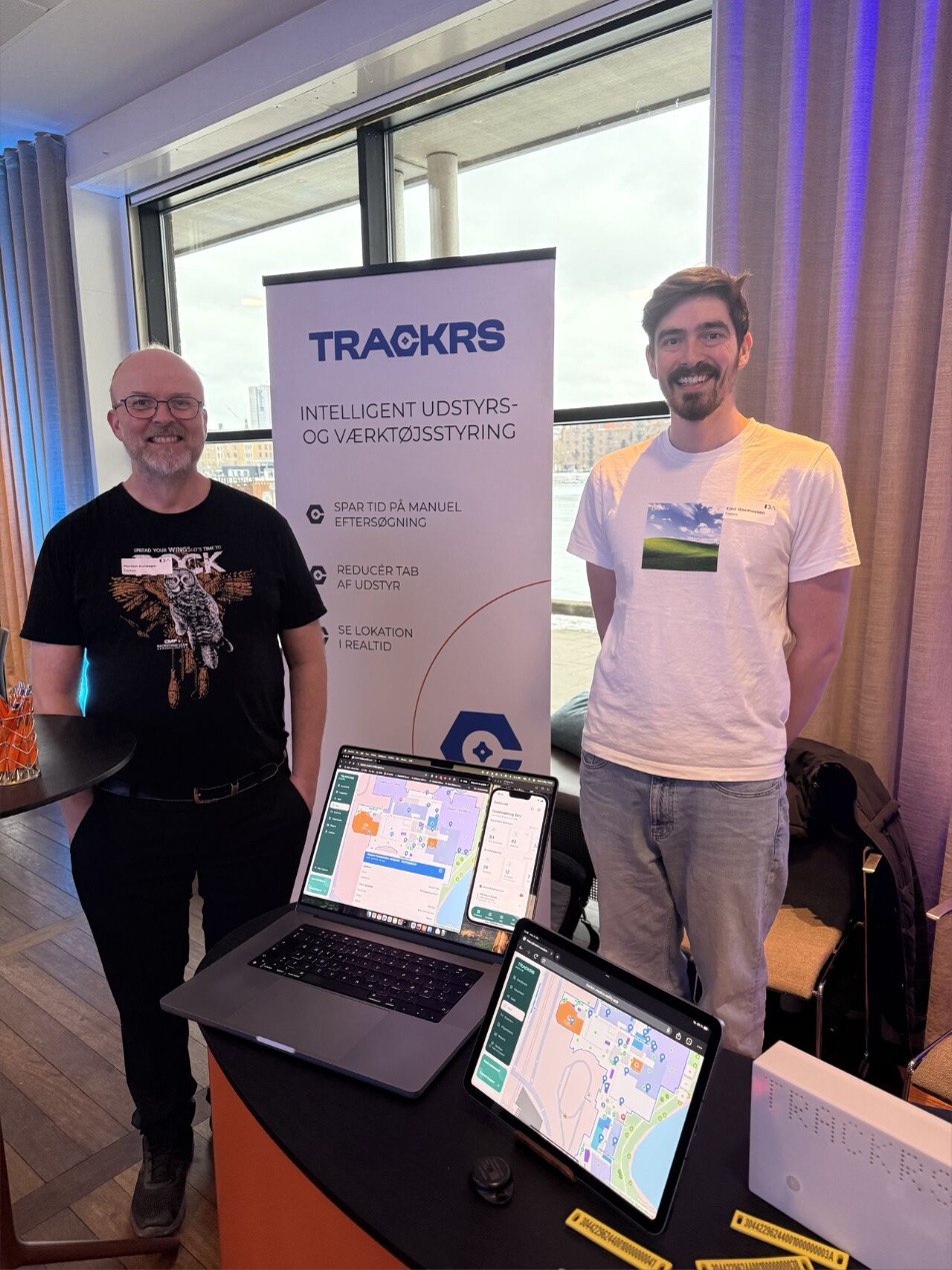 Trackrs-standen med roll-up, bærbar og tablet klar til demo